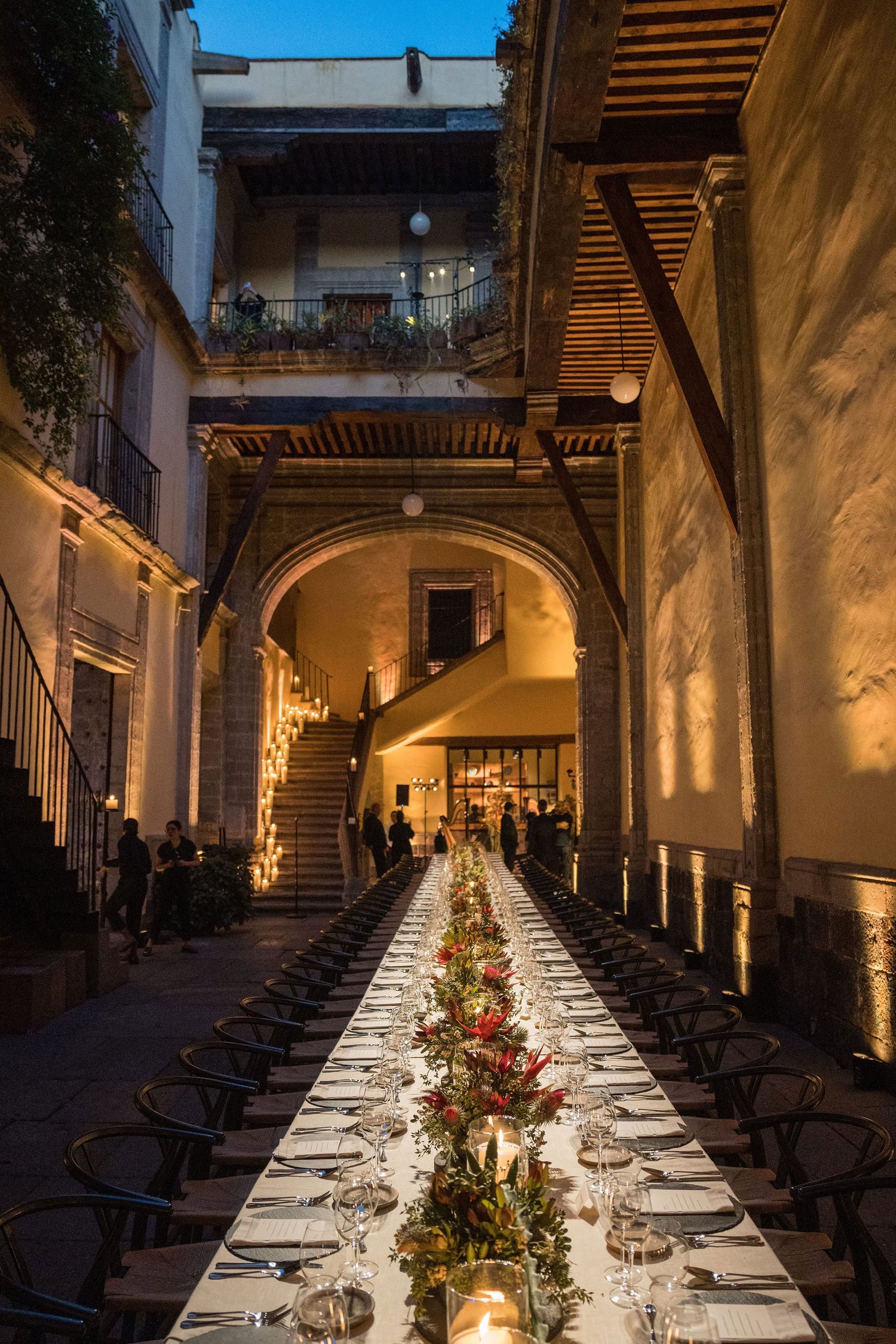 Warmly lit historic courtyard and candlelit dining table at Seminario 12